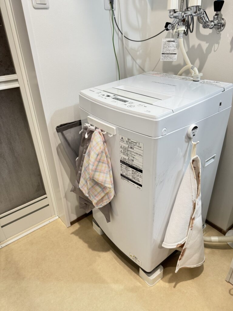 洗濯機です。奥に洗濯かごを収納しています。